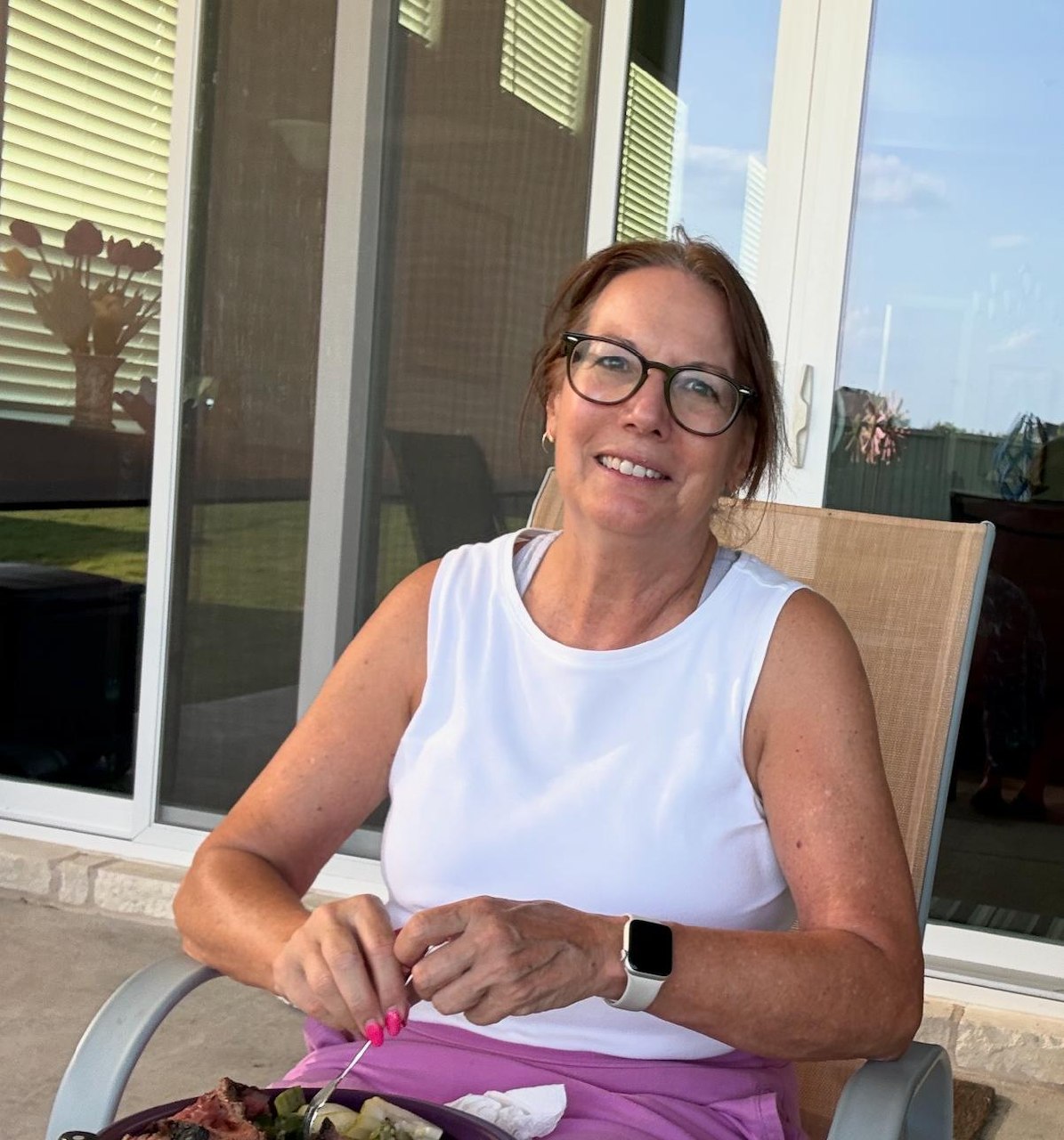 Carol seated outside on a patio